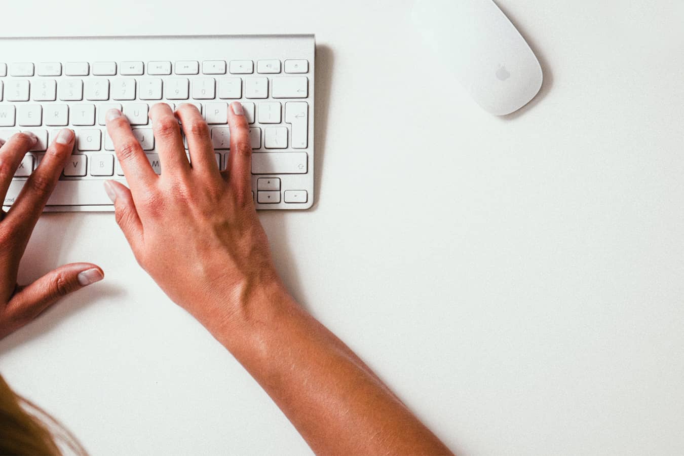 Market research company hands typing on a white keyboard