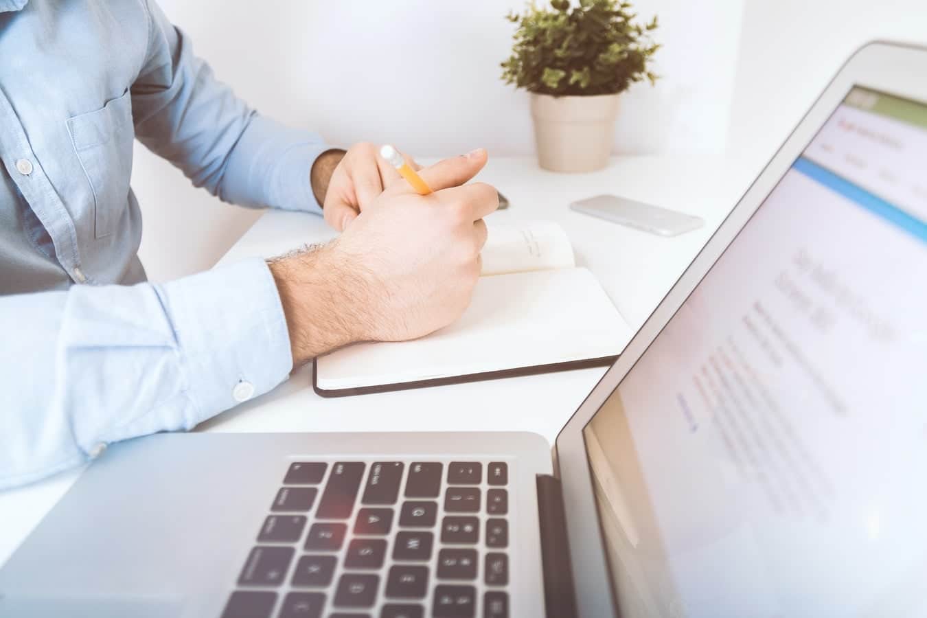 B2B market research companies researcher with laptop and notepad in an office