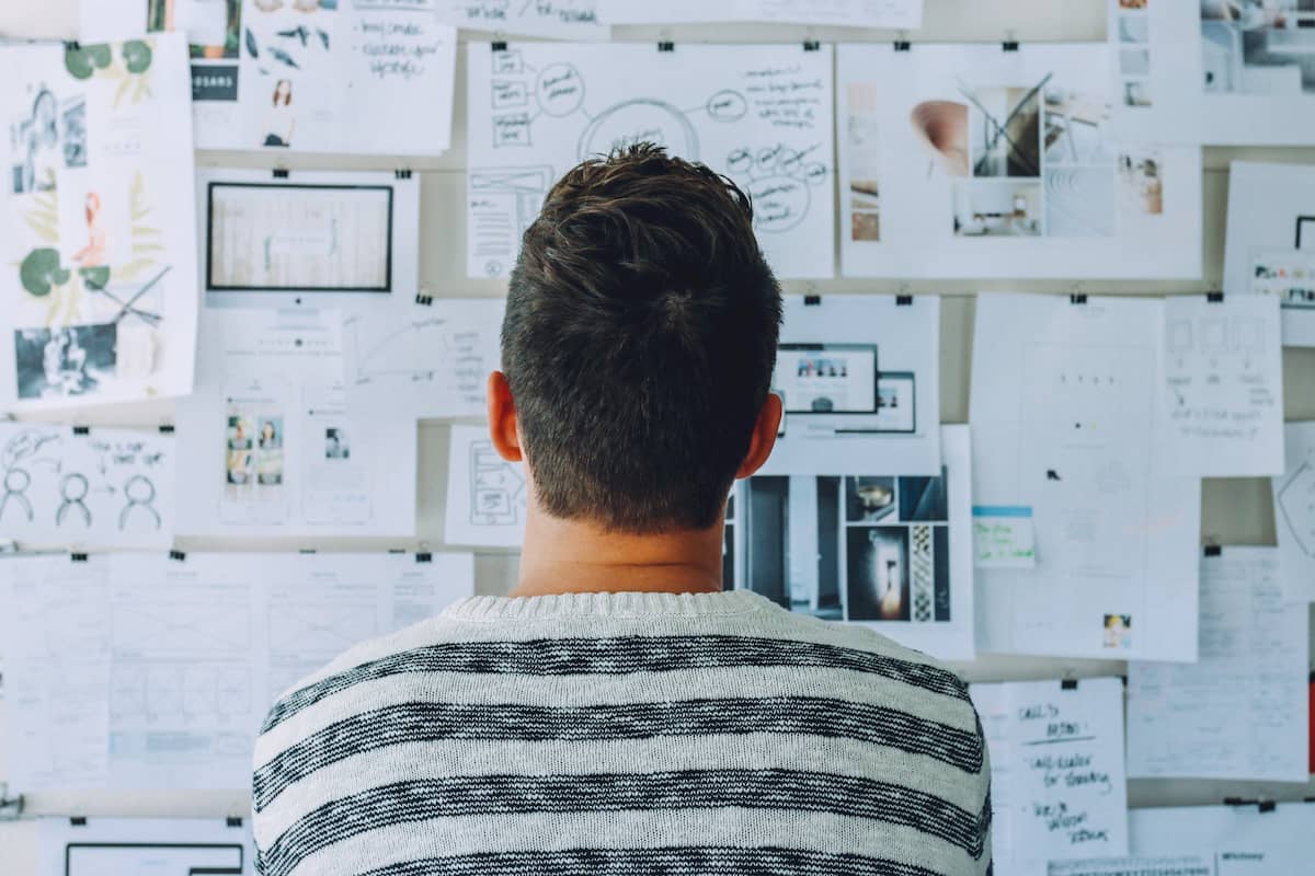 Man looking at a wall of metrics and graphs