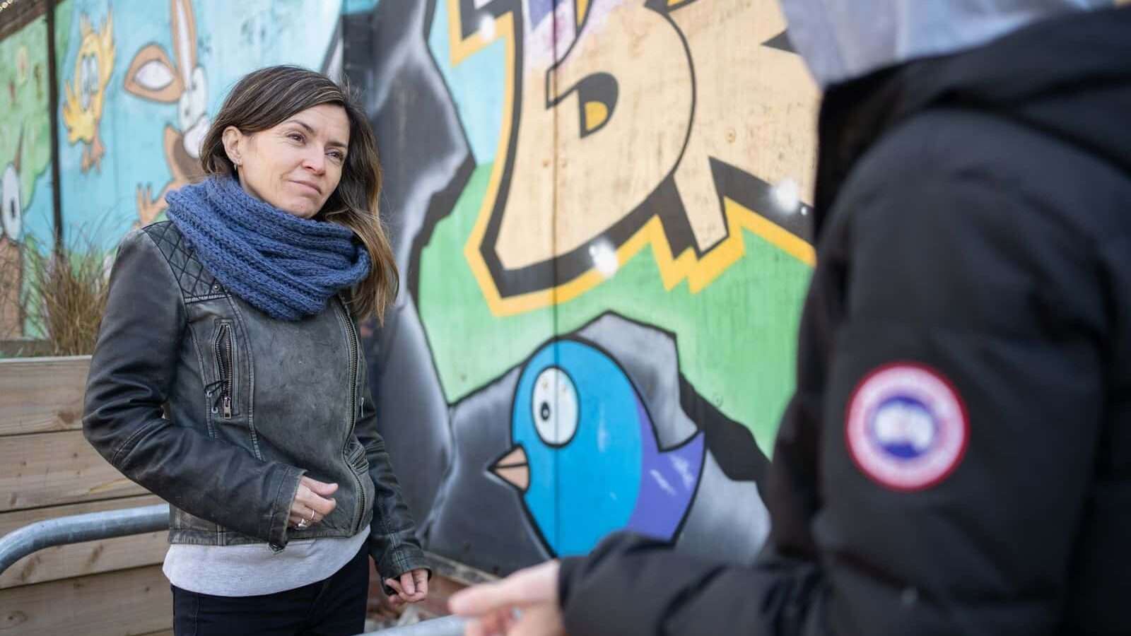A female researcher conducting a survey with a man in the street | Humanistic Approach | Mackman Research Market Research Agency