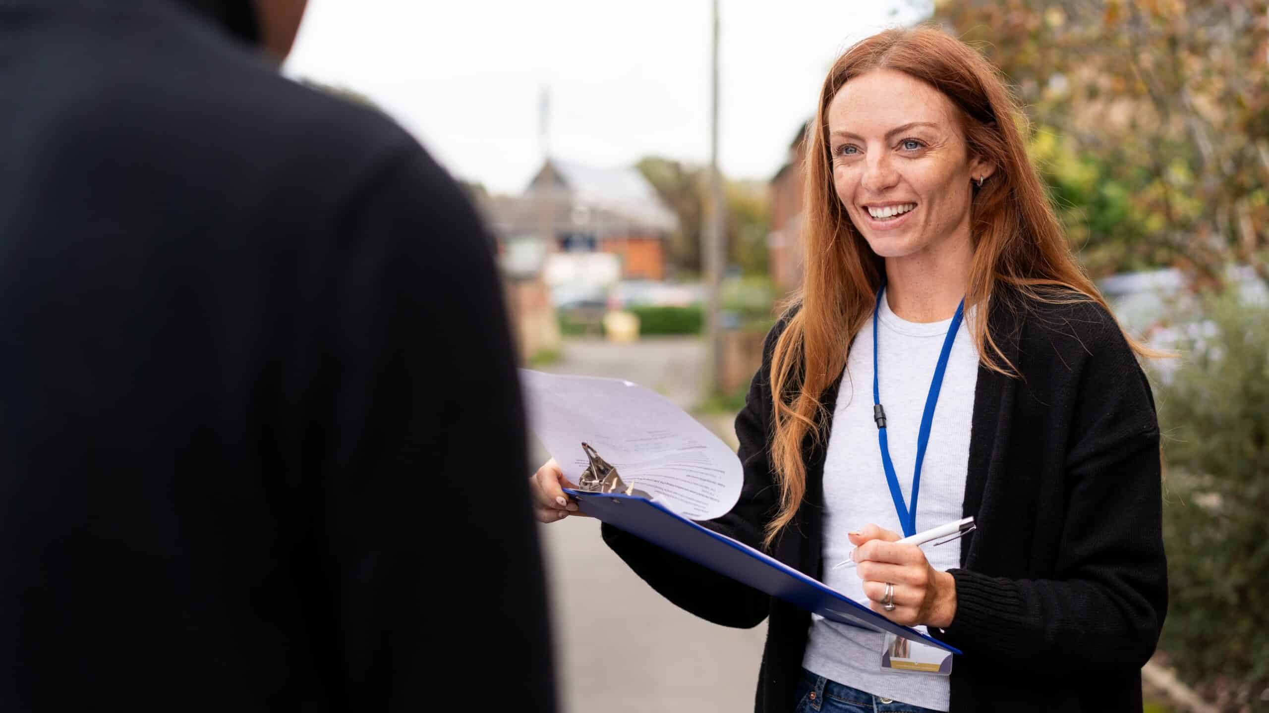 A female researcher conducting a survey with a man in the street | Humanistic Approach | Mackman Research Market Research Agency